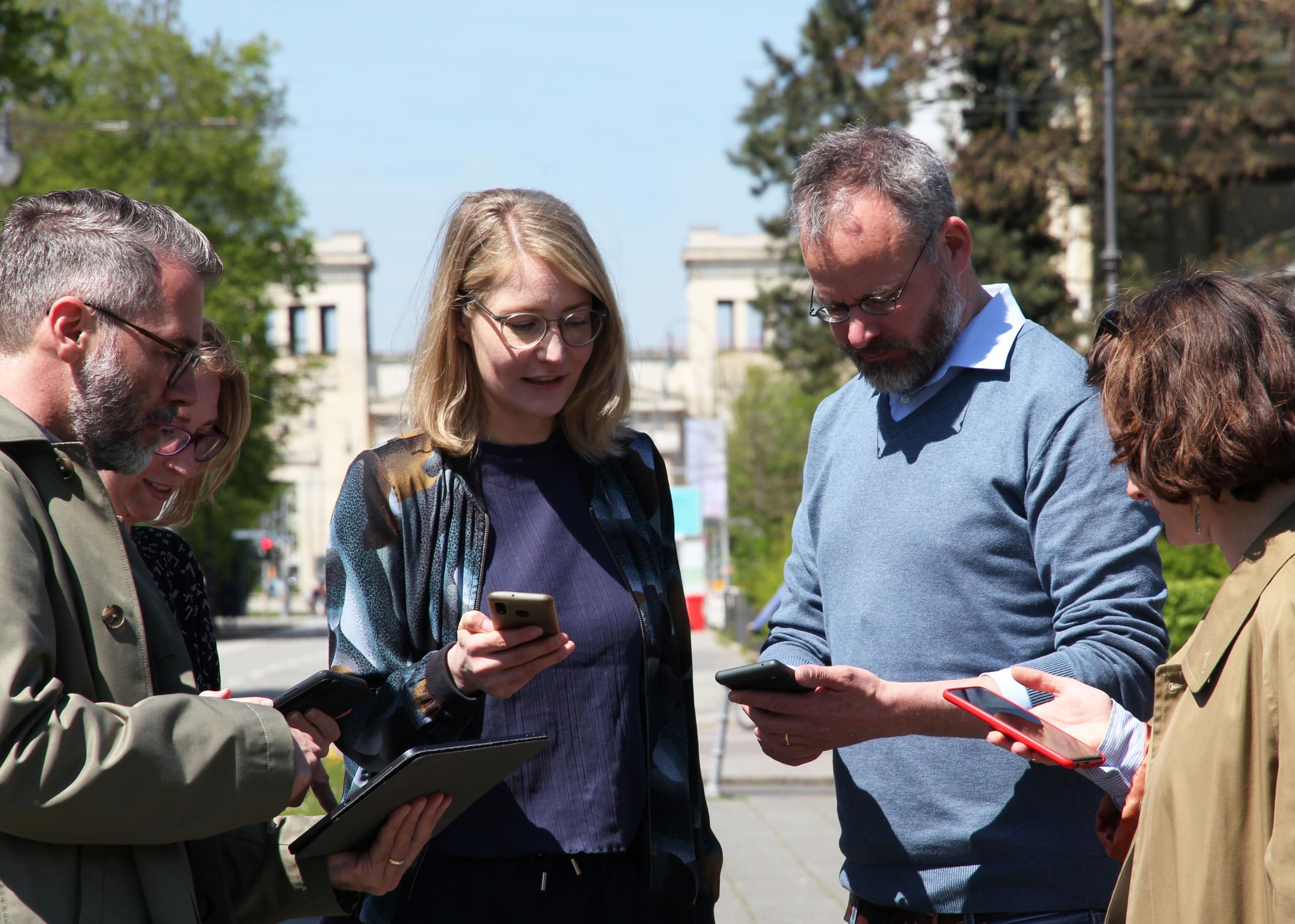 Eine Gruppe von Frauen und Männer steht mit Handys beisammen. Foto: Susanne Spieler